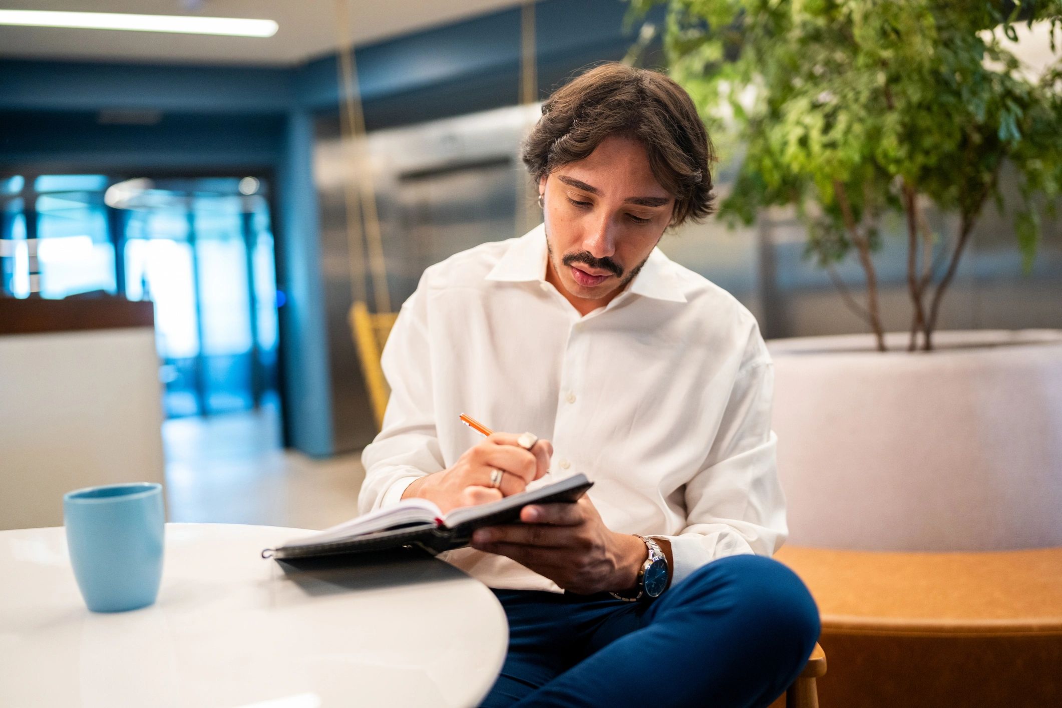 Writer taking notes in a bright office lobby